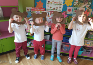 Czwórka dzieci z grupy zajączki pozuje w misiowych maskach